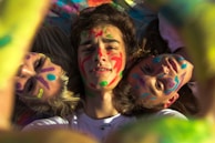 Couple laughing while applying paint to each other's bodies before pressing to canvas