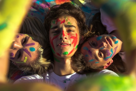 A cozy paint party scene with friends laughing and painting colorful canvases together.