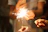 Close-up of sparklers glowing brightly in hands during a festive gathering.