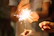 Close-up of sparklers glowing brightly in hands during a festive gathering.