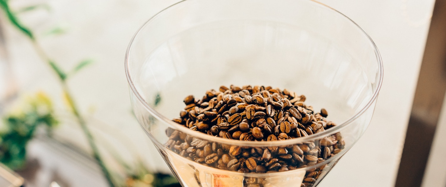 brown coffee beans on clear glass cup