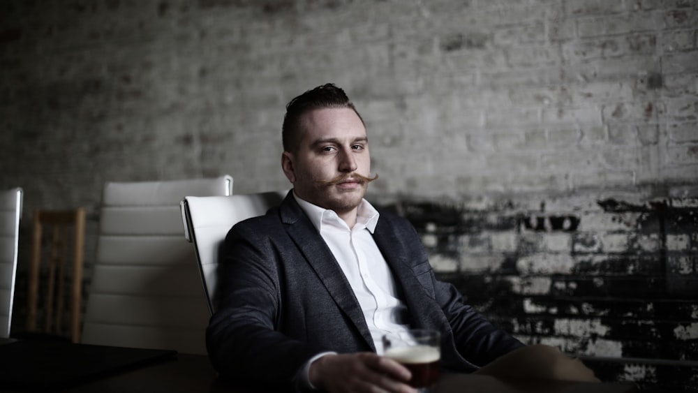 man sitting on white chair inside room