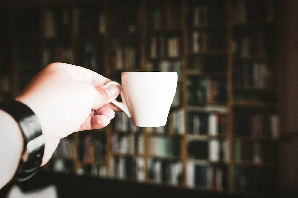 person holding teacup at daytime