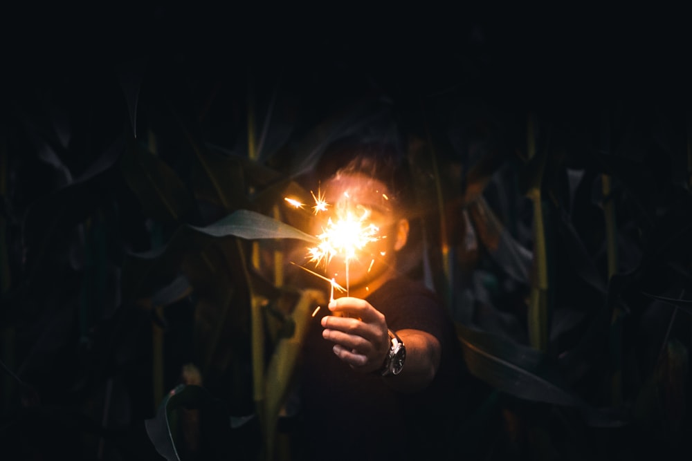 man holding sparkler at nighttime