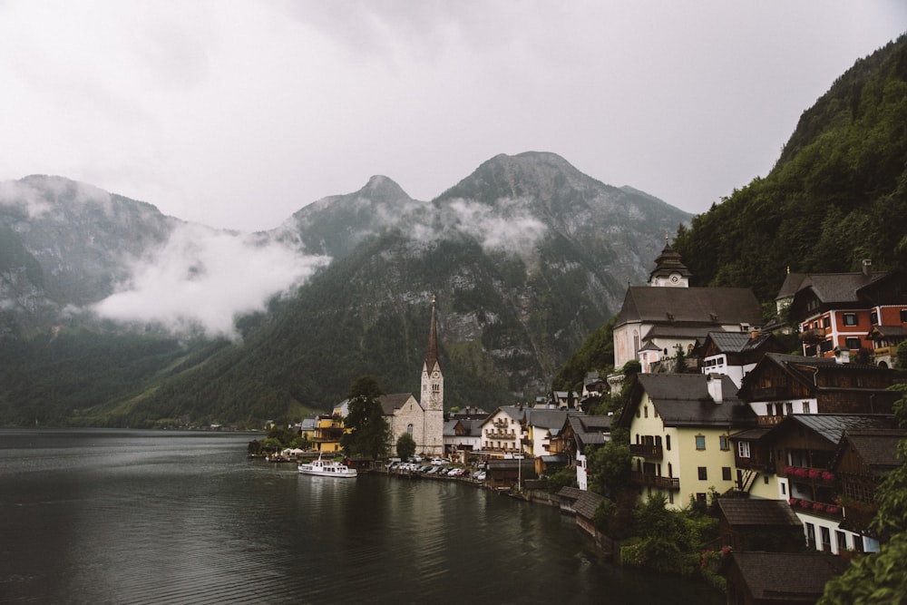 body of water near houses and mountain