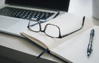 black framed eyeglasses and black pen