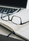 black framed eyeglasses and black pen