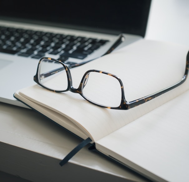 black framed eyeglasses and black pen