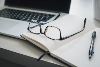 black framed eyeglasses and black pen