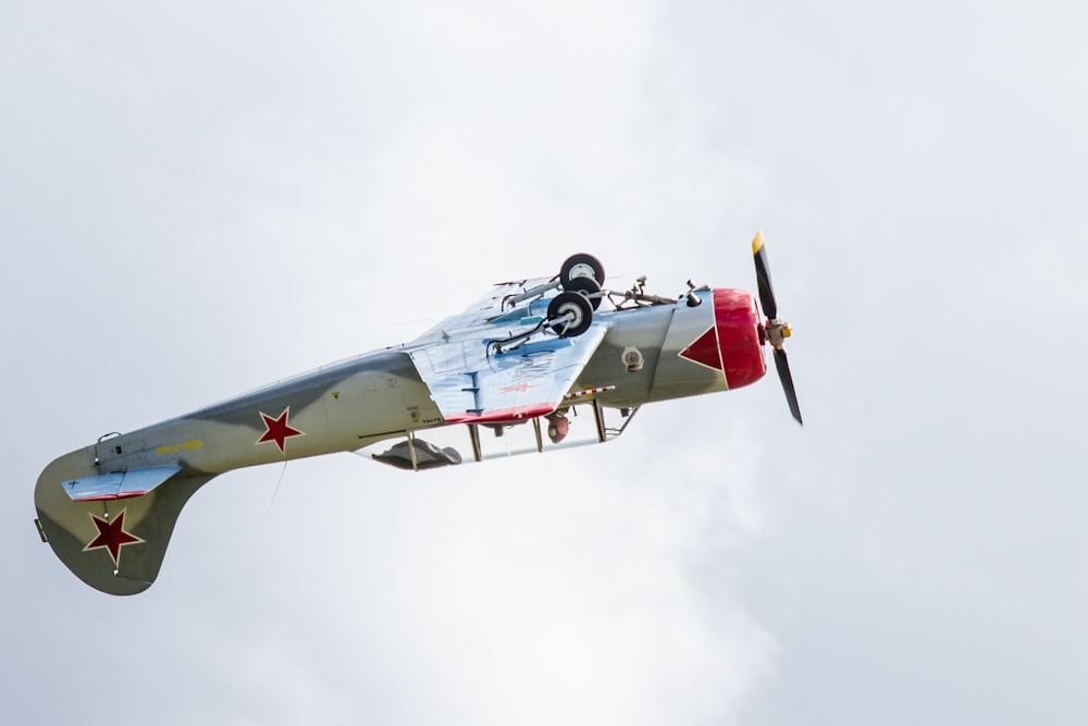 avion gris et rouge faisant une cascade