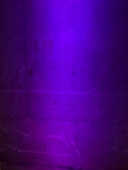 Close-up of textured concrete wall with geometric patterns under soft lighting.