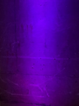 Close-up of textured concrete wall with geometric patterns under soft lighting.