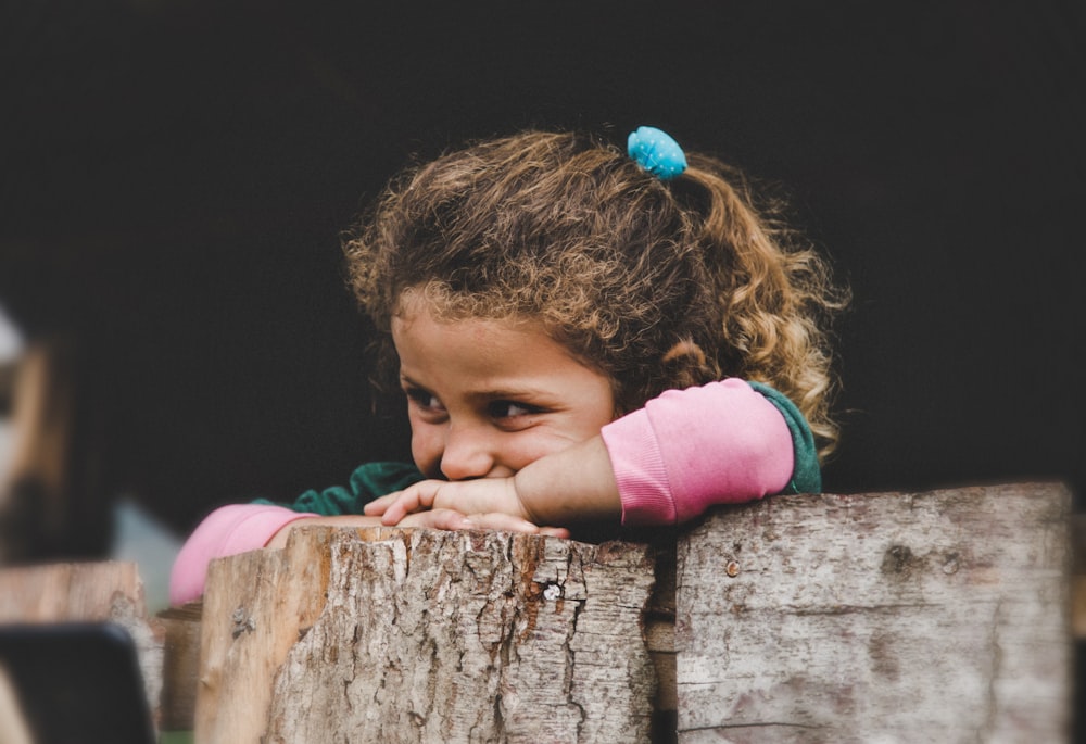 girl leaning on wood log