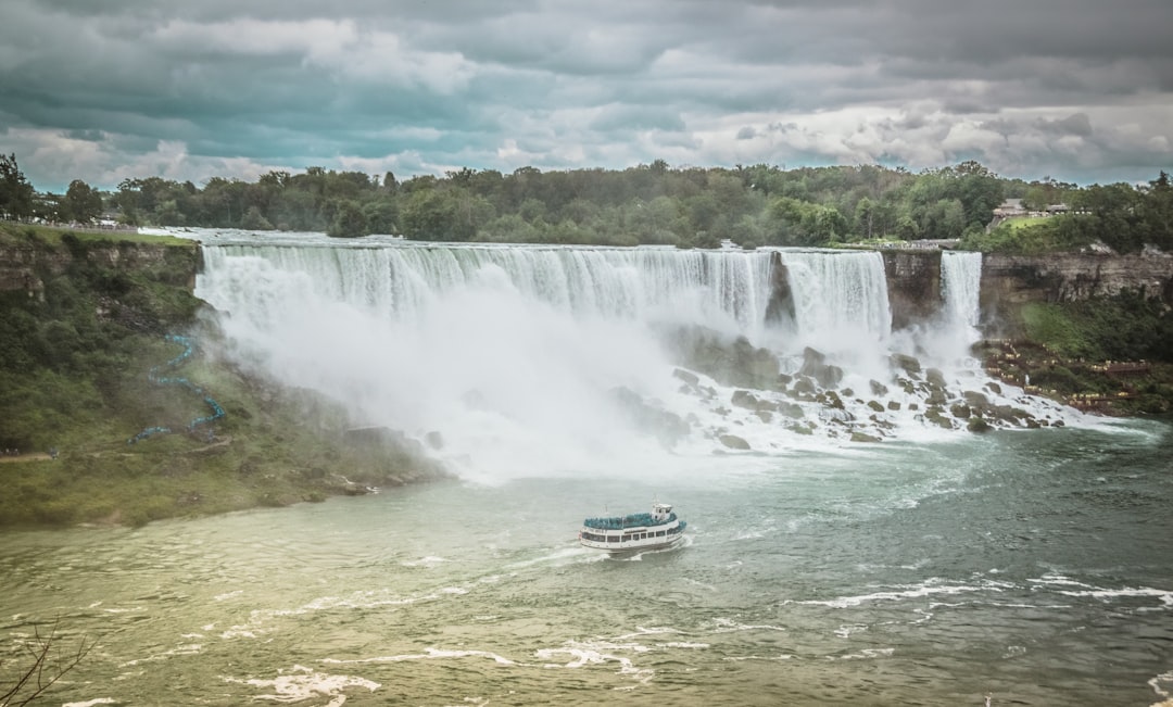 blue and white boat on water falls during daytime