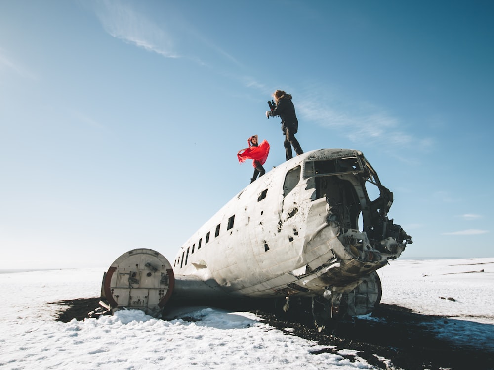 two person standing on top of wrecked airplane at daytime