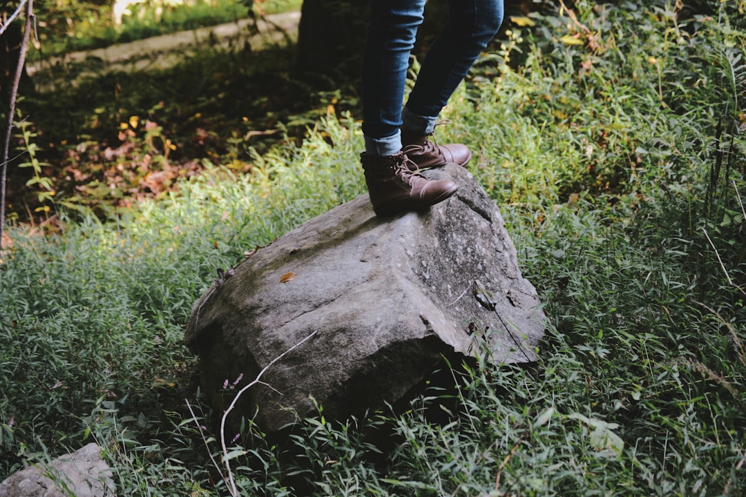 person standing on gray rock