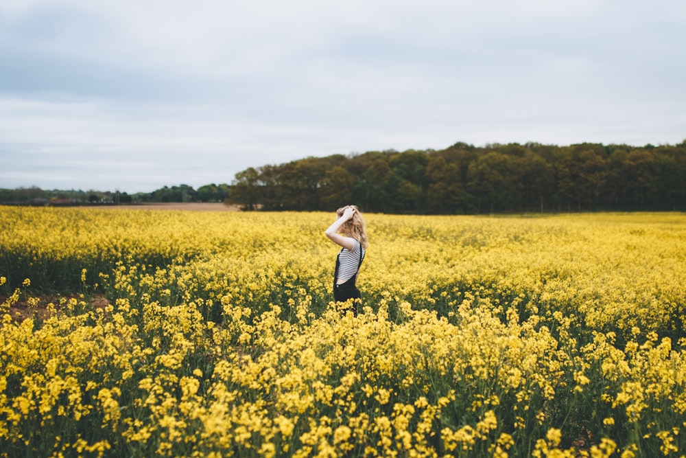 woman standing on bed of yellow flowers