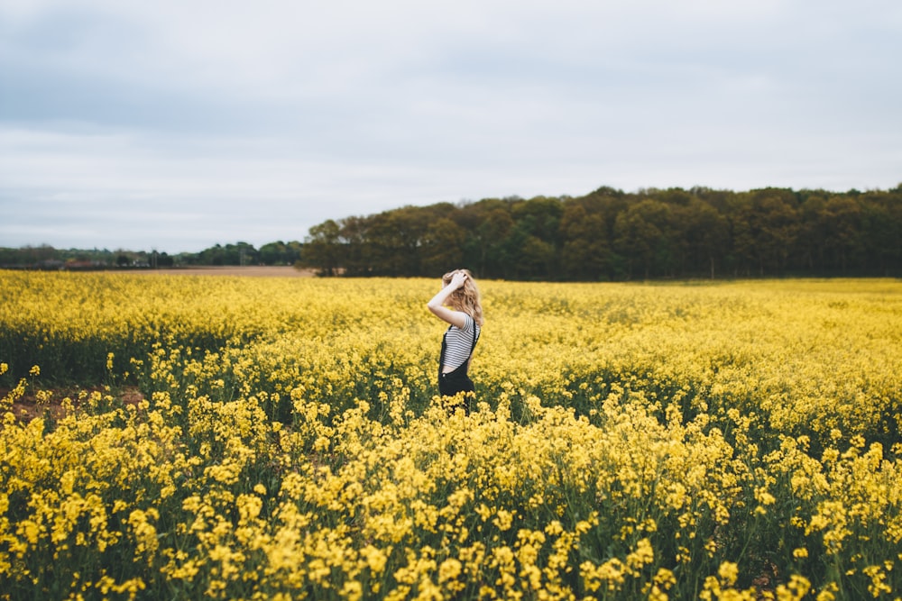 donna in piedi sul letto di fiori gialli