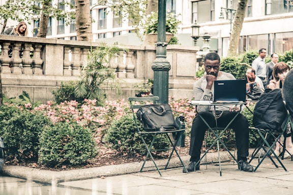 A friendly community member using a laptop outdoors in a Bogotá neighborhood.