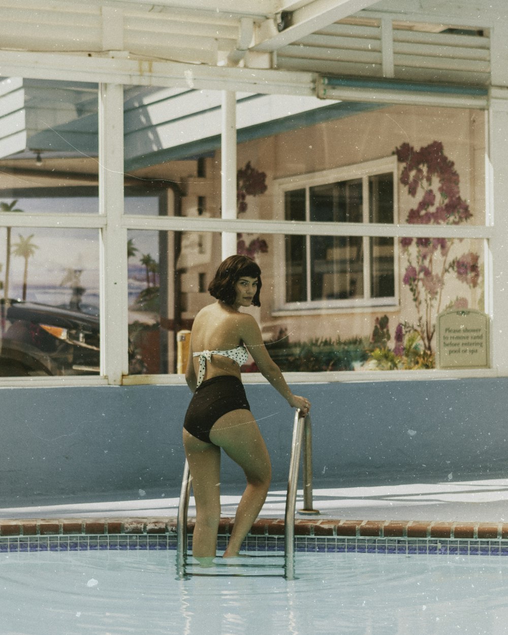 woman standing on pool ladder at daytime