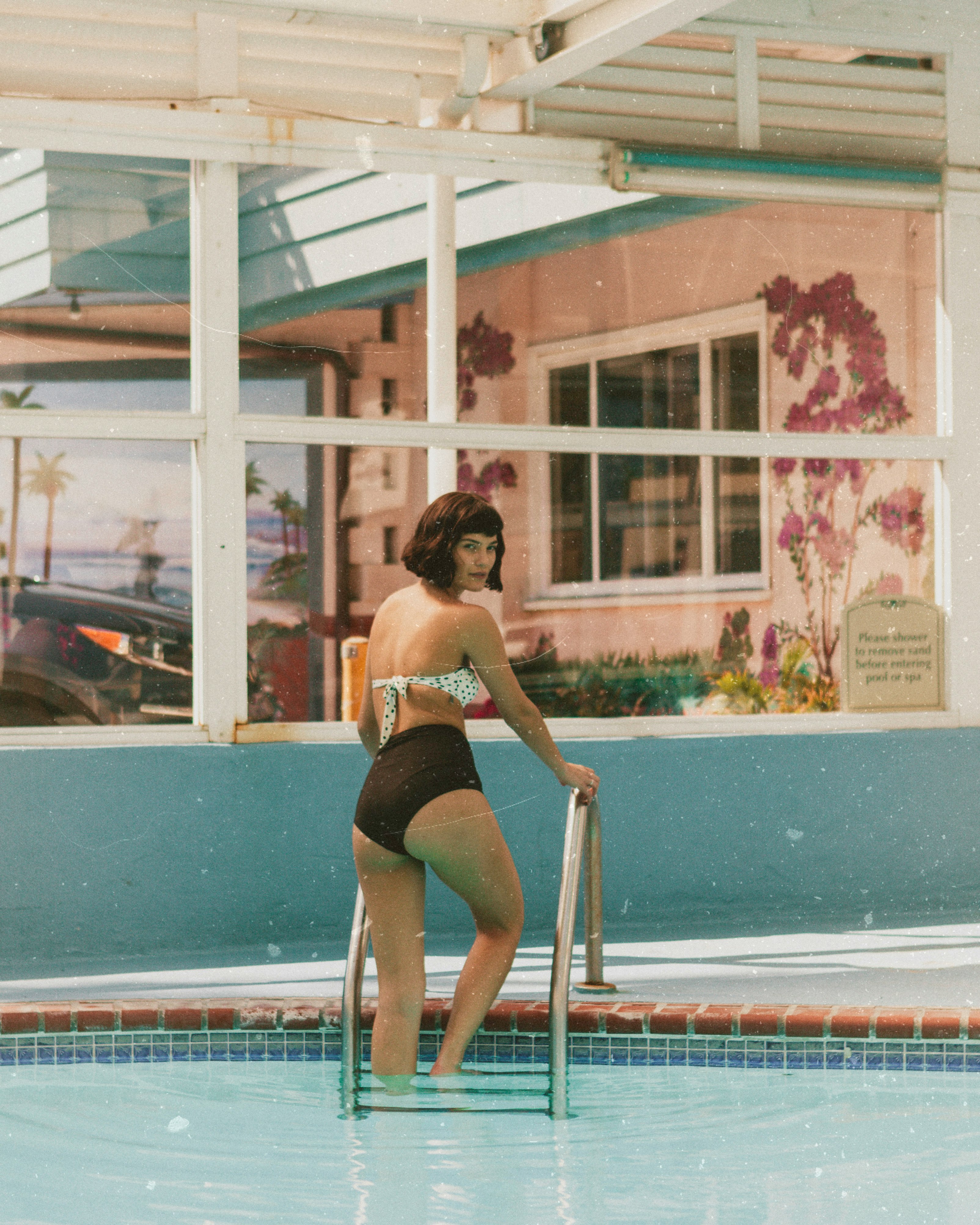 woman standing on pool ladder at daytime