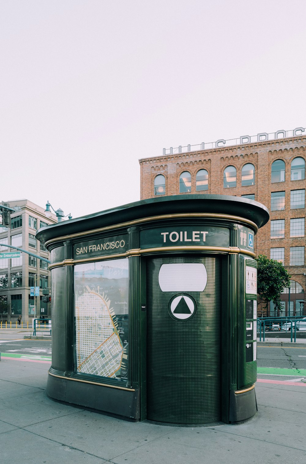 a green toilet sitting on the side of a road