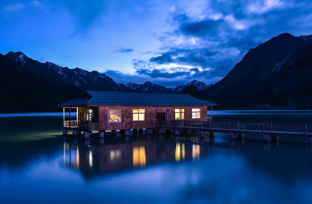 house at the lake with bridge near mountains