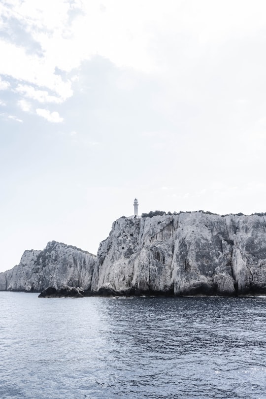 grayscale photography of lighthouse on cliff in Cape Lefkadas Greece