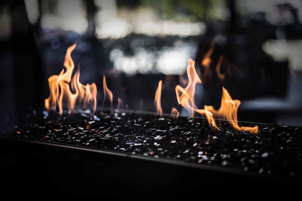 Flames of a charcoal stone fireplace on an outdoor patio