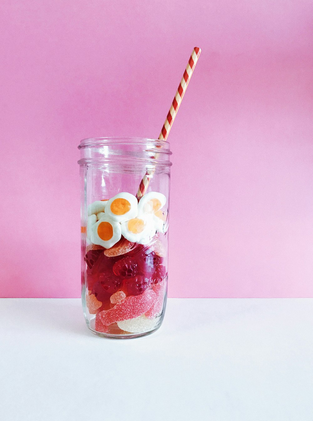 clear glass bottles with jelly beans and straw