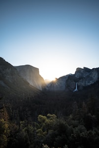 A cinematic shot of a videographer capturing a sunrise over the lush landscapes of North Sulawesi.