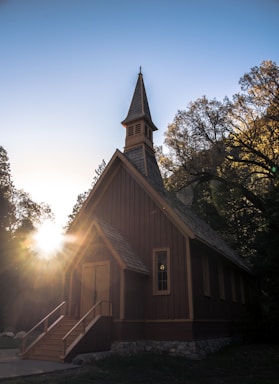 A warm, inviting photo of the Living Faith Chapel building at sunset with soft glowing lights.