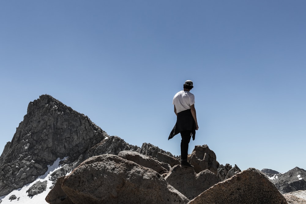 man standing on rock mountain peak