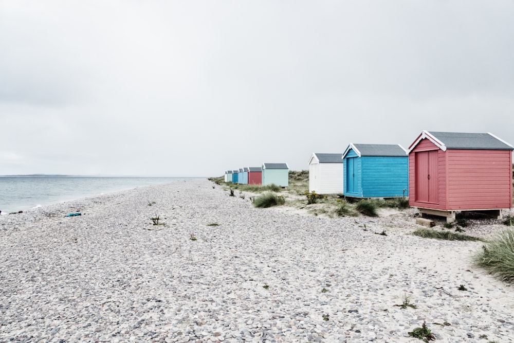 assorted-color sheds near seashore at daytime