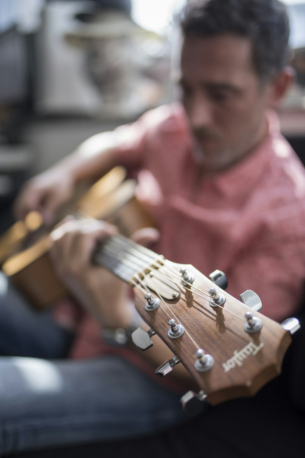 Flachfokusfotografie eines Mannes, der Gitarre spielt