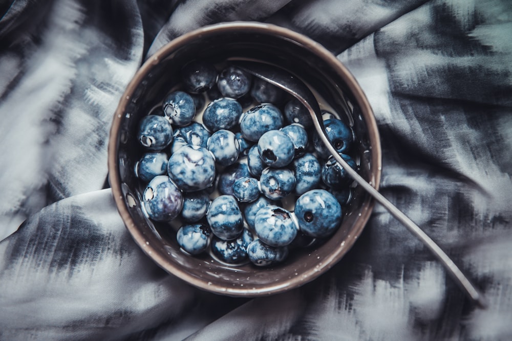 Baies bleues au lait dans un bol en céramique brune
