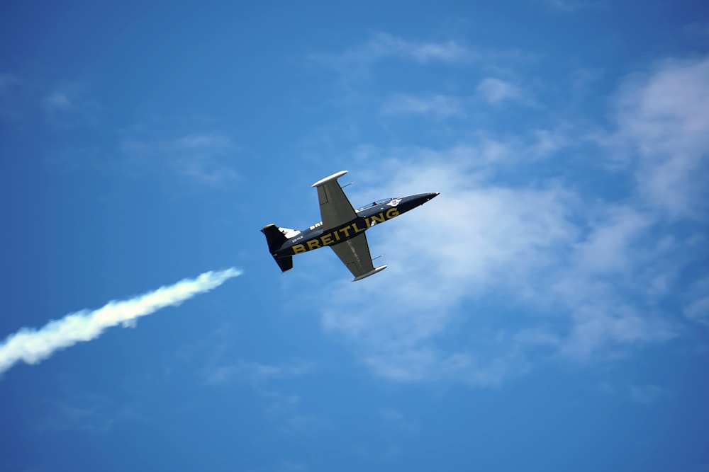 Low-Angle-Foto eines grauen und schwarzen Breitling-Flugzeugs