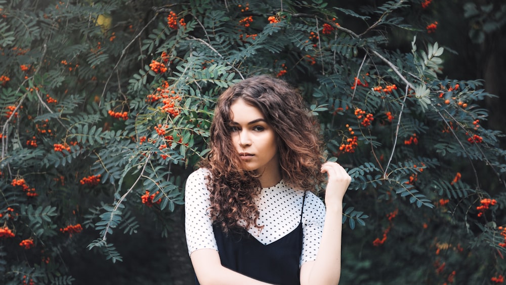 woman in front red peacock tree