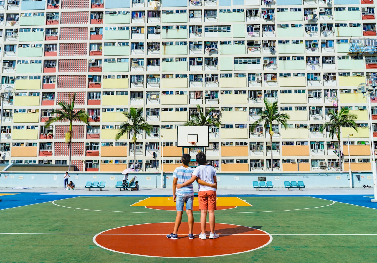 apartment building with two men standing on a basketball court looking upward
