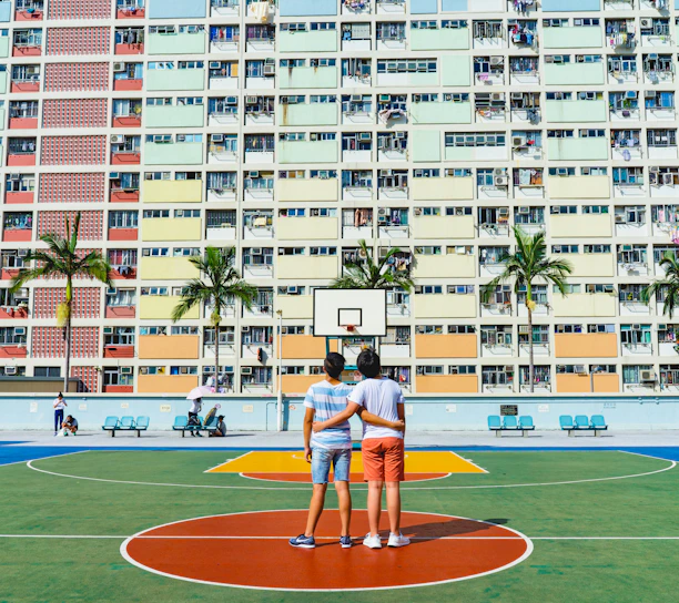 minimalist photography of two men standing on basketball court looking upwards
