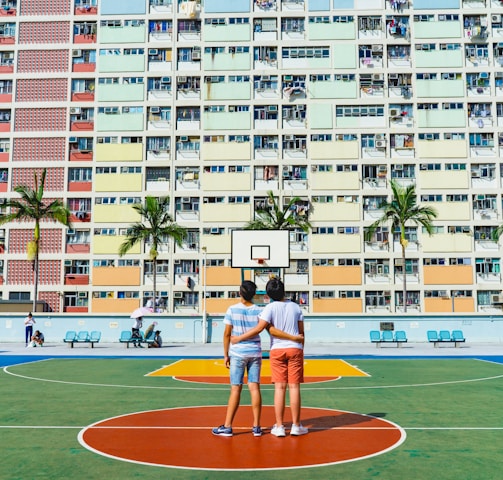 minimalist photography of two men standing on basketball court looking upwards