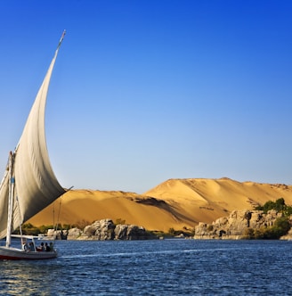 white sailboat on water under blue cloudy sky during daytime photo