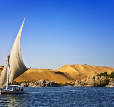 white sailboat on water under blue cloudy sky during daytime photo