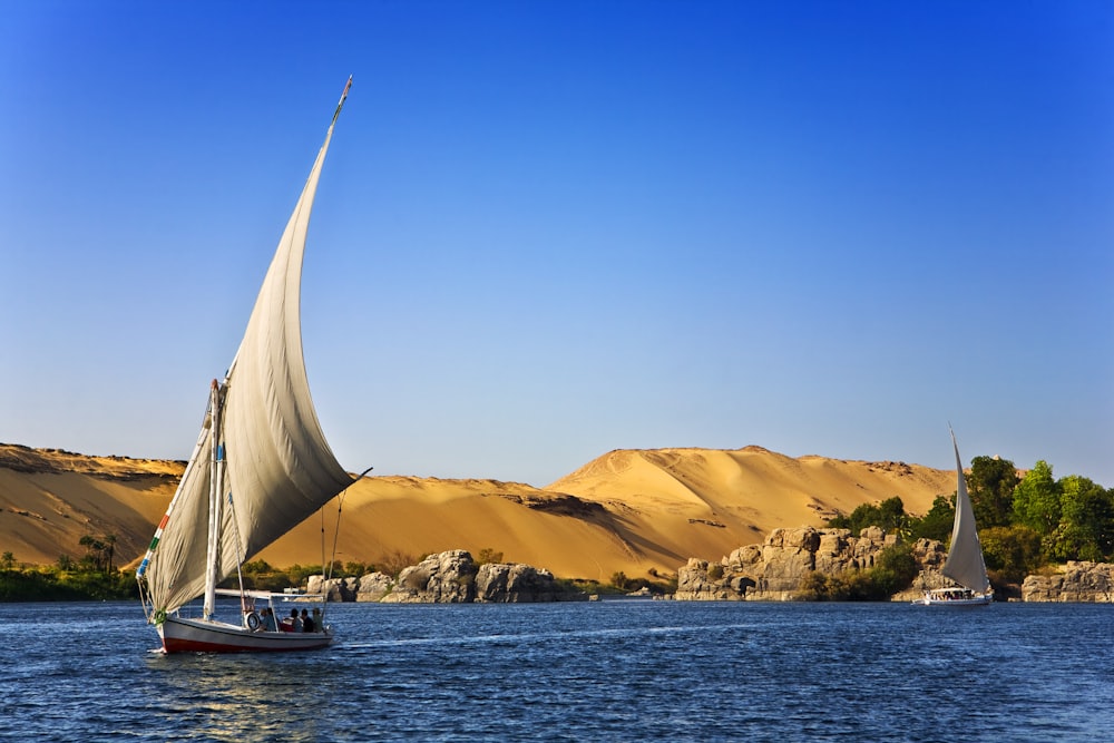 white sailboat on water under blue cloudy sky during daytime photo