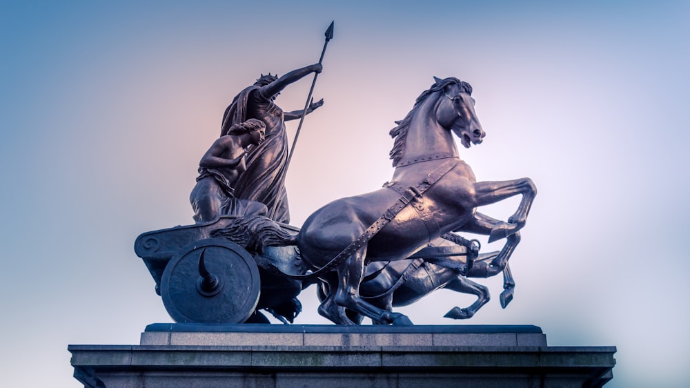 zwei Männer reiten Kutsche Statue