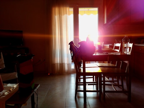 A warm kitchen table set with a homemade meal, sunlight streaming through a nearby window.