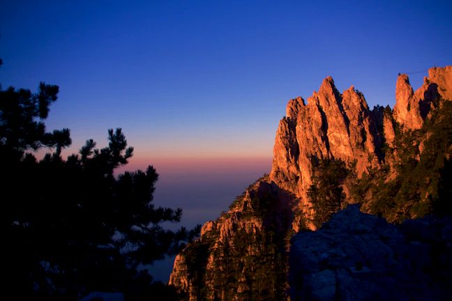 Evening glow illuminating the rugged mountain silhouettes behind Dar Eid eco lodge.