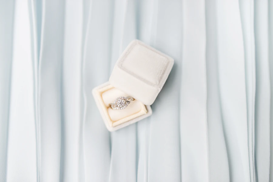 Diamond ring in an ivory ring box on draped fabric