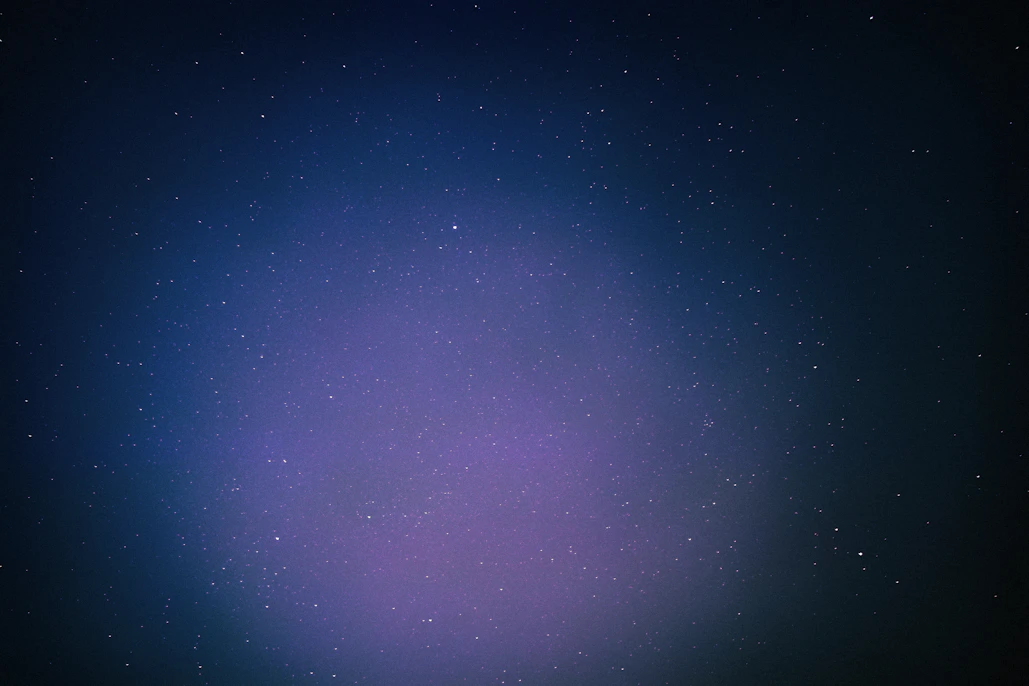 A vast, dark cosmic landscape with distant stars and a faint glowing horizon.