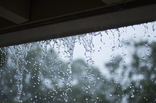 Close-up of rainwater smoothly draining through a gutter system during a light shower.